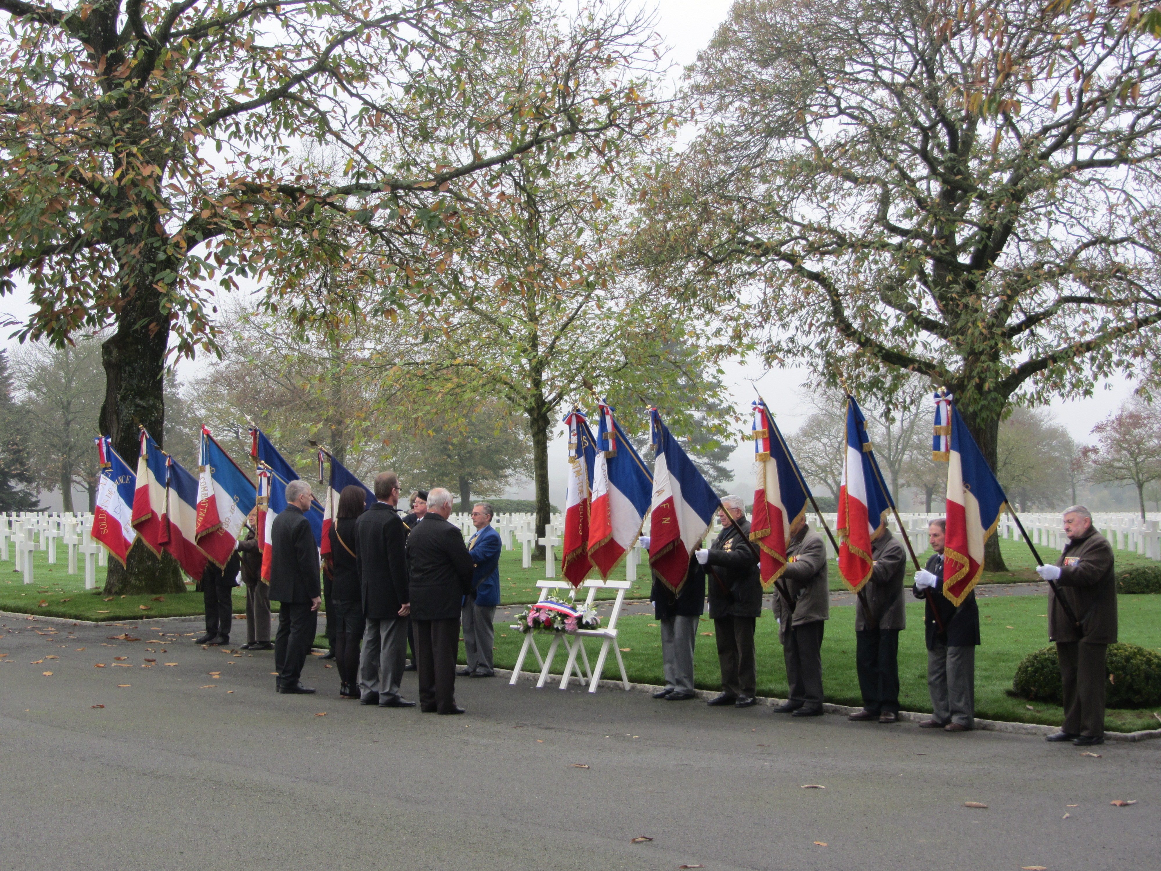 Flag bearers flank the wreath as town officials present it during the ceremony. 