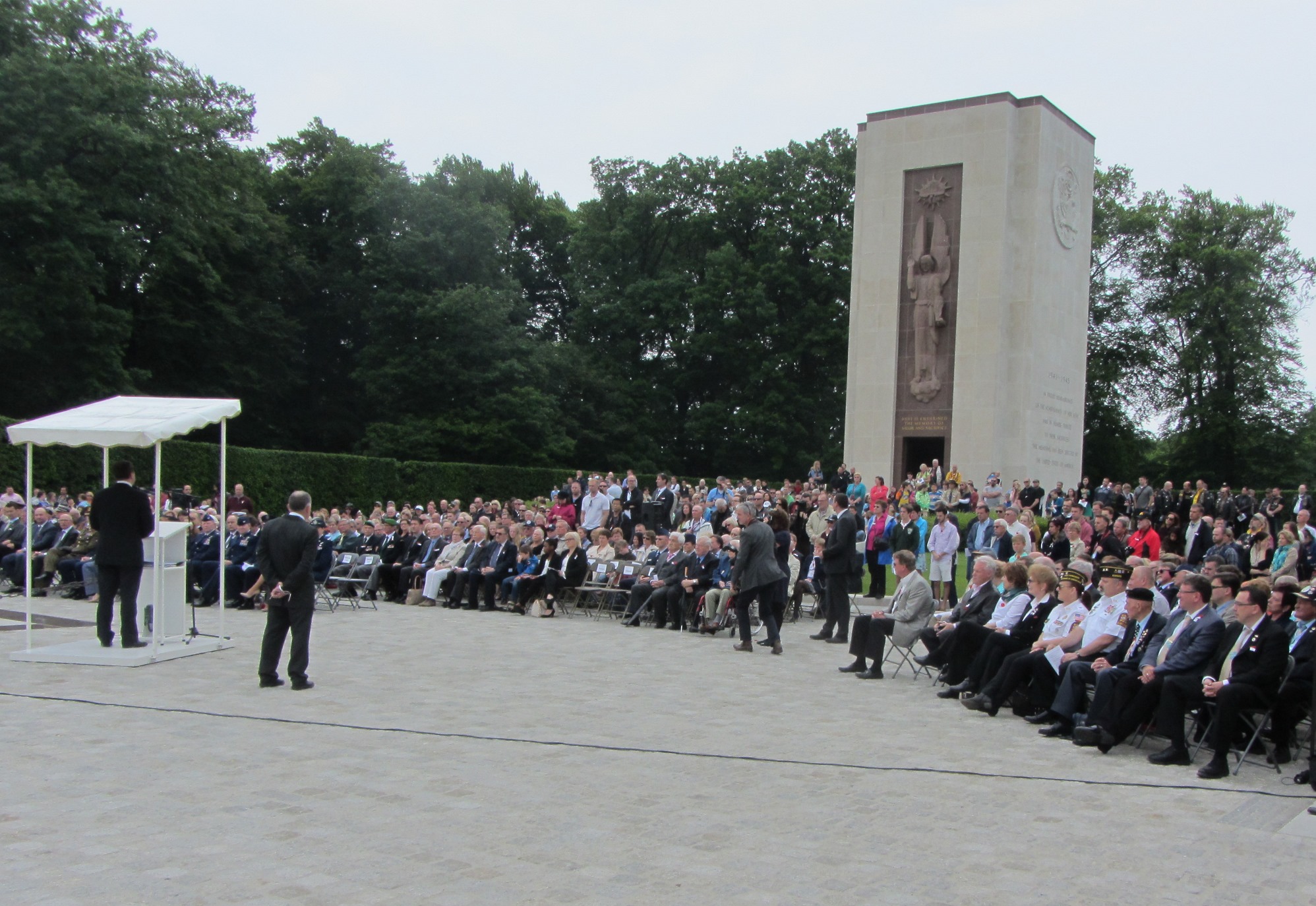 Most crowd members sit during the Memorial Day ceremony. 
