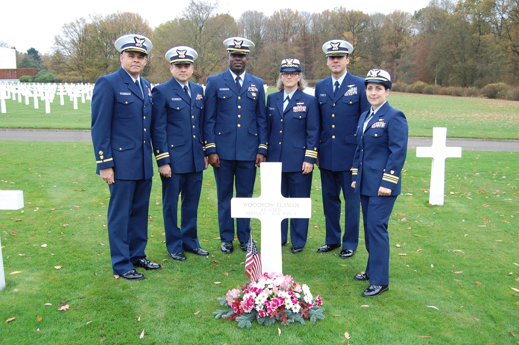 Six members of the Coast Guard stand at Elaman's headstone. 
