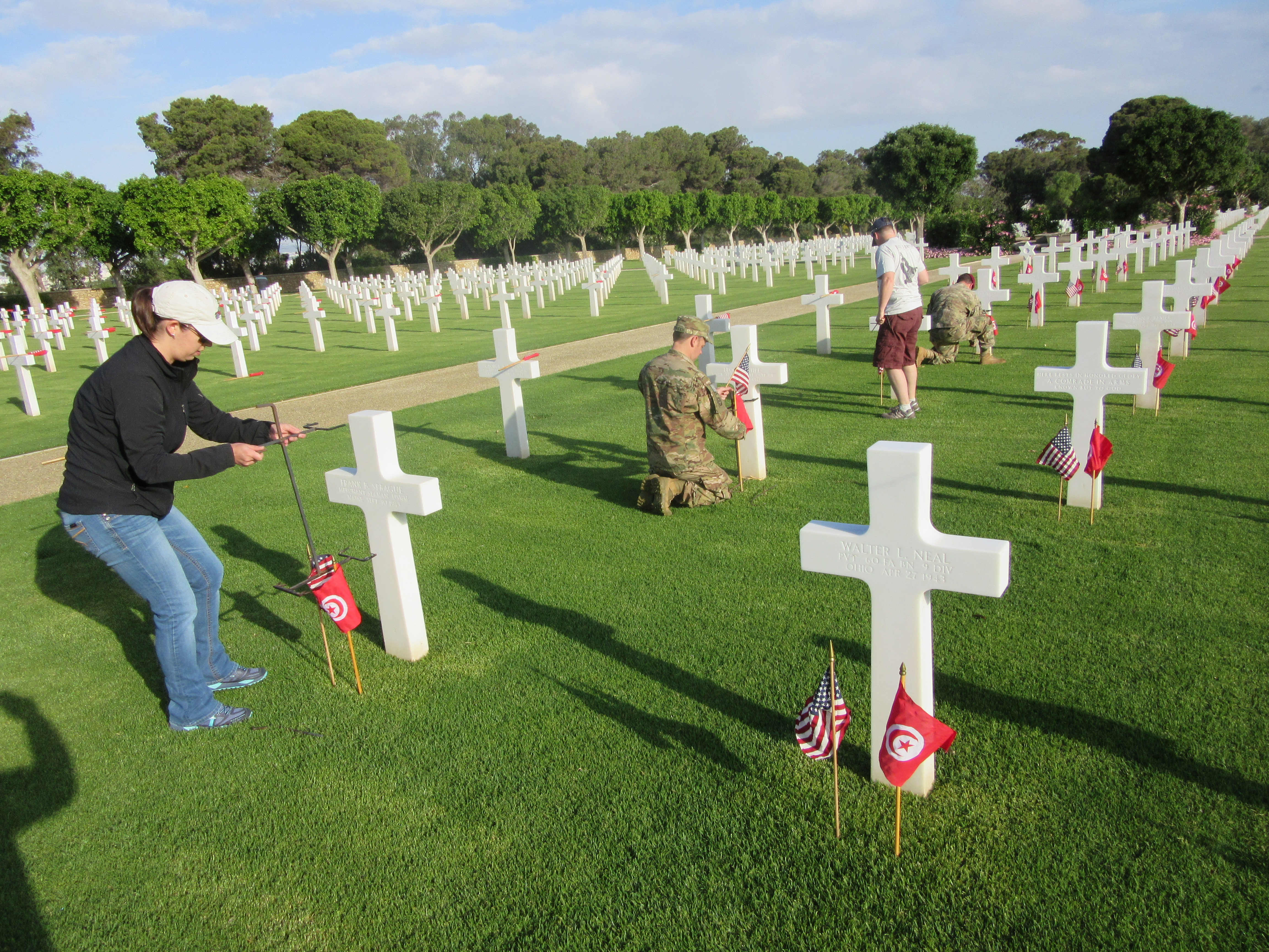 Volunteers place an American flag and Tunisian flag in front of every headstone. 
