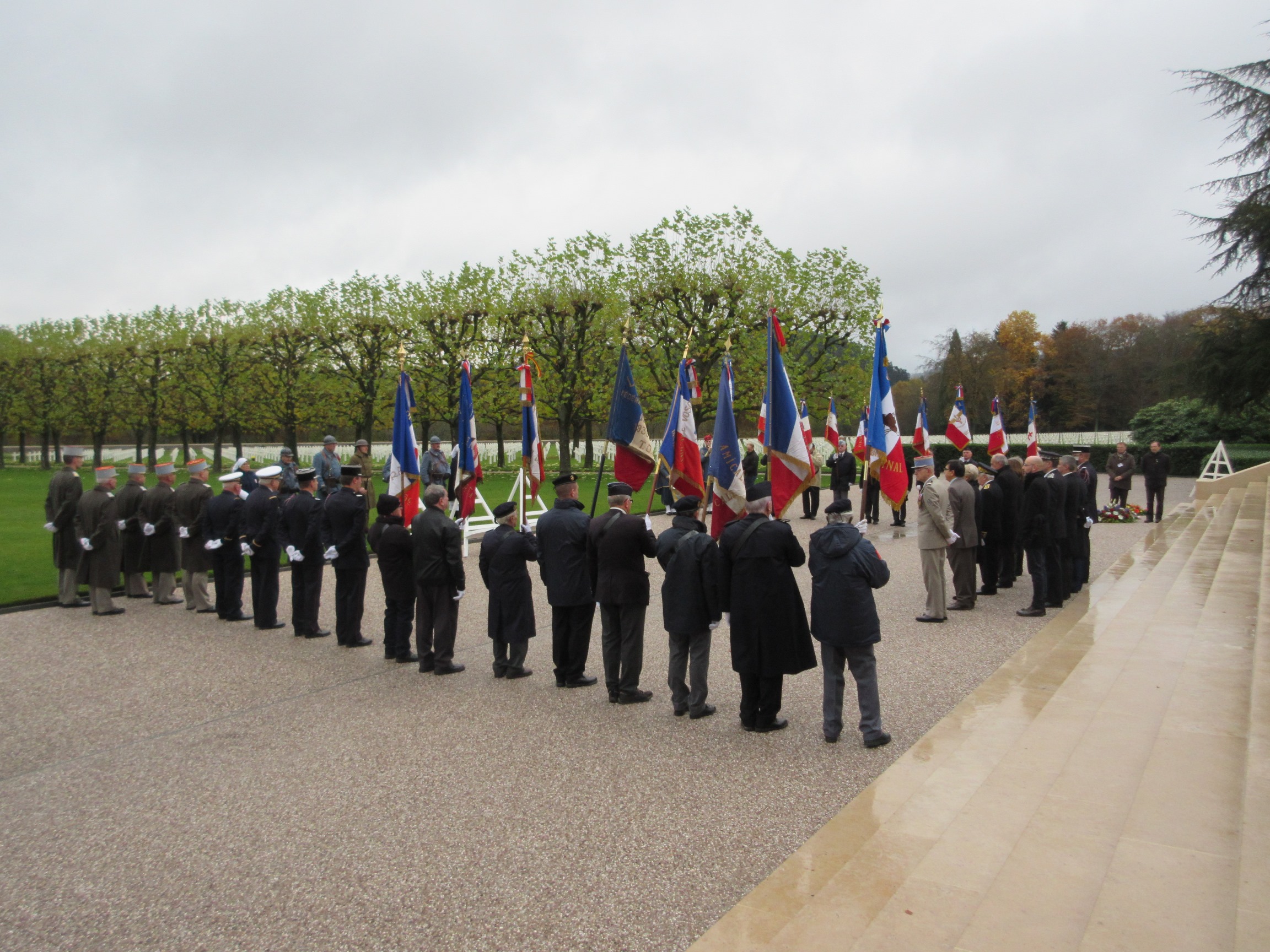 Ceremony participants stand and face the wreath-laying area. 