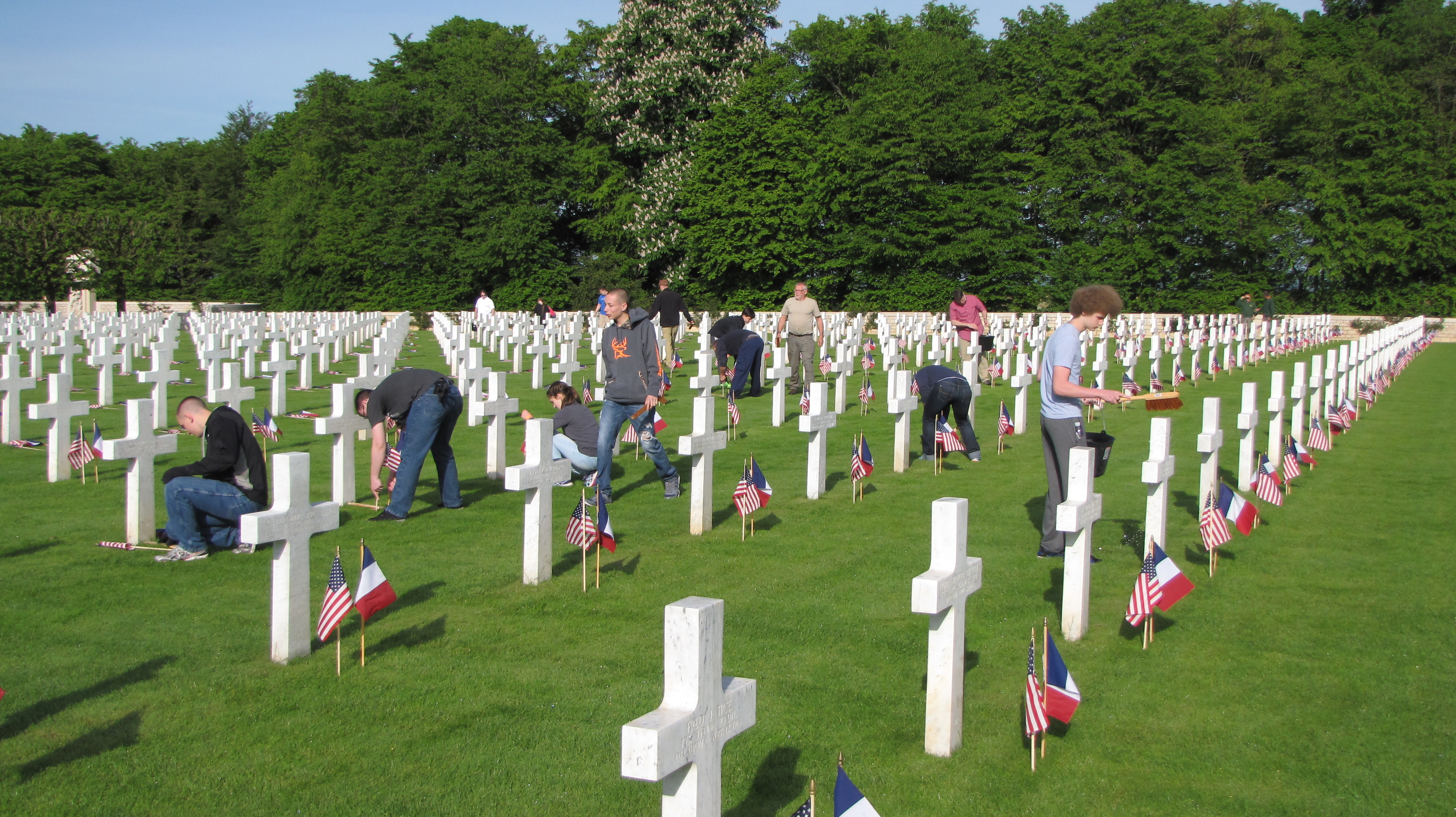 Volunteers place American and French flags in front of every headstone. 