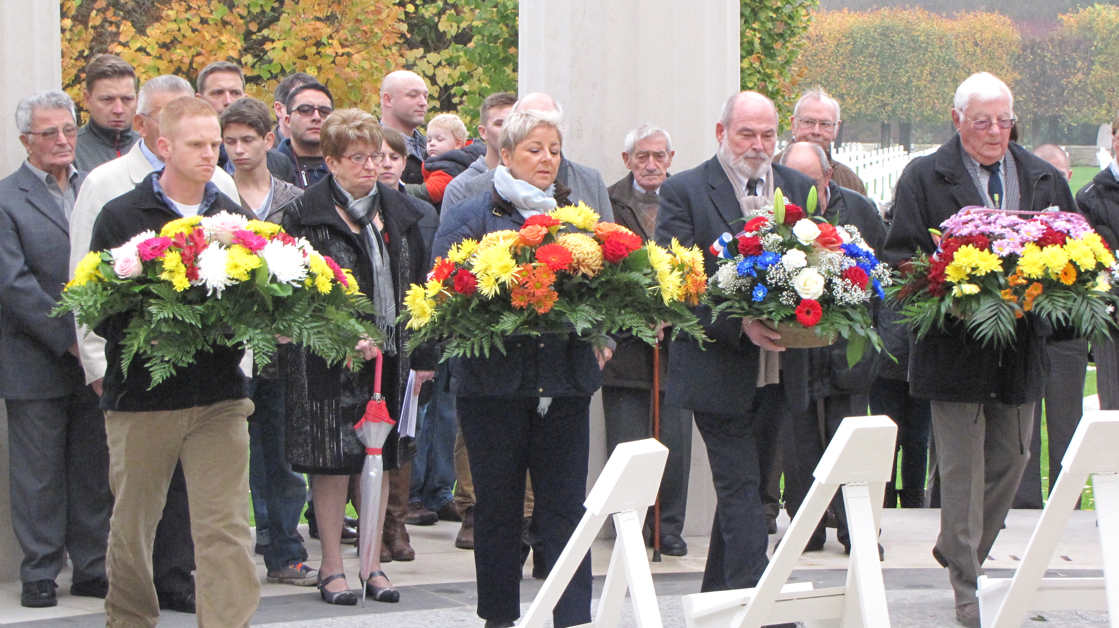 Four large floral wreaths are laid by members of the official party during the ceremony. 