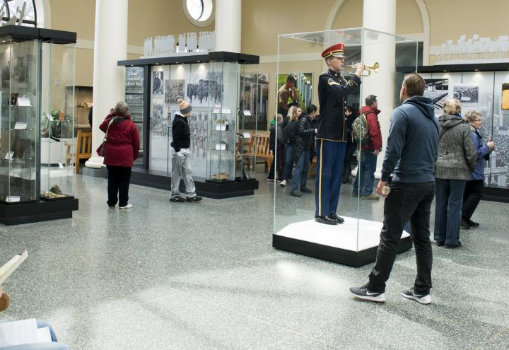 Visitors stand in front of the exhibits to read and view the photos.