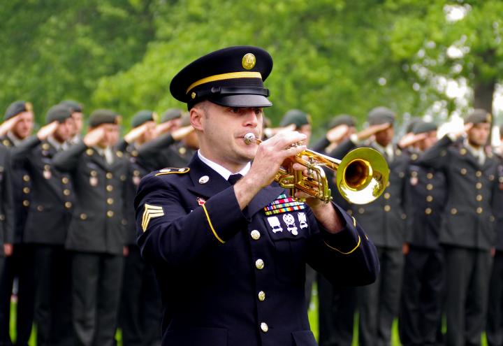 A man in uniform plays a trumpet during the ceremony. 