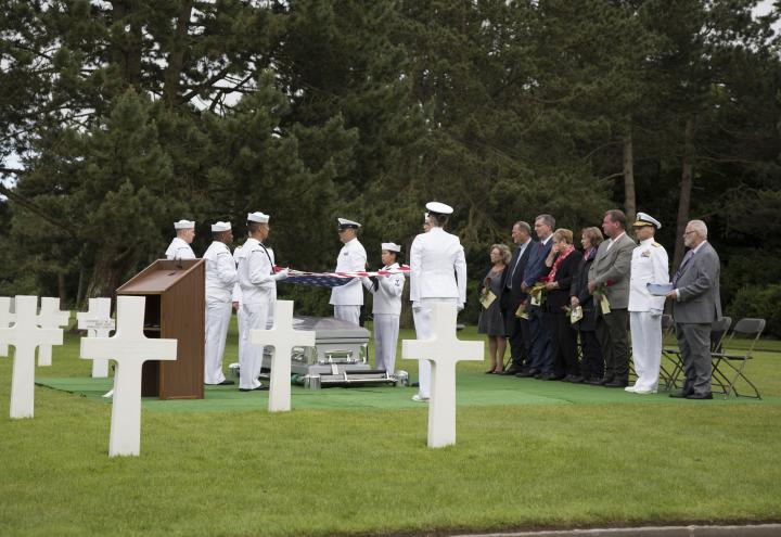 Sailors and family members stand during this solemn ceremony. 