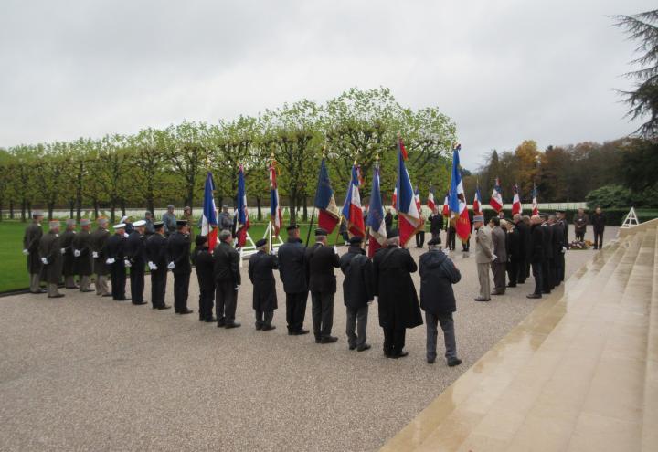 Ceremony participants stand and face the wreath-laying area. 