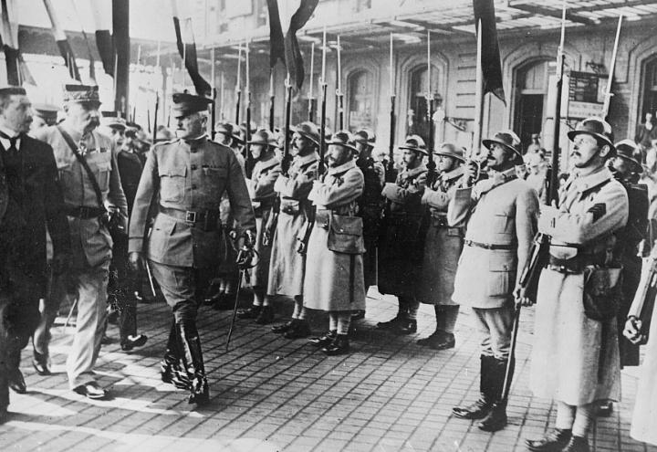 Historic photo of Pershing arriving, with lines of French troops greeting him. 