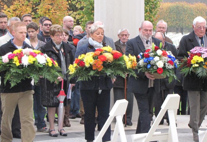 Four large floral wreaths are laid by members of the official party during the ceremony. 