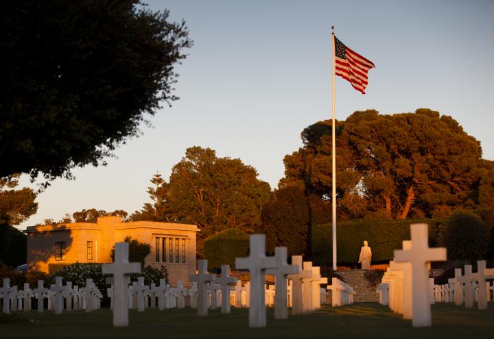 Headstones, the American flag and the memorial building at North Africa American Cemetery. 