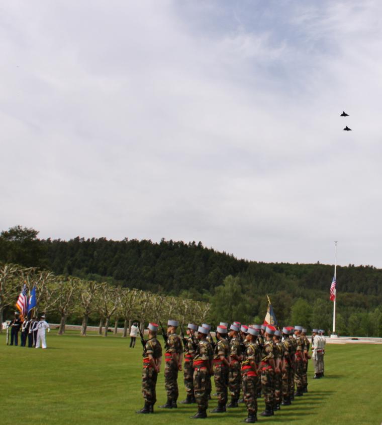 Two fighter planes fly over the cemetery grounds. 