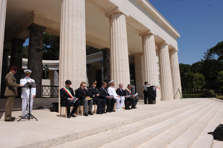 The official party sits in front of the memorial during the ceremony. 
