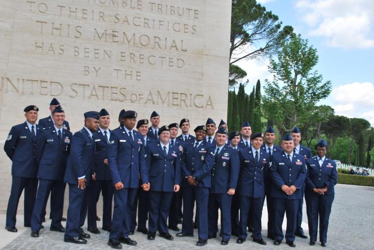 Men and women in uniform stand in a group. 