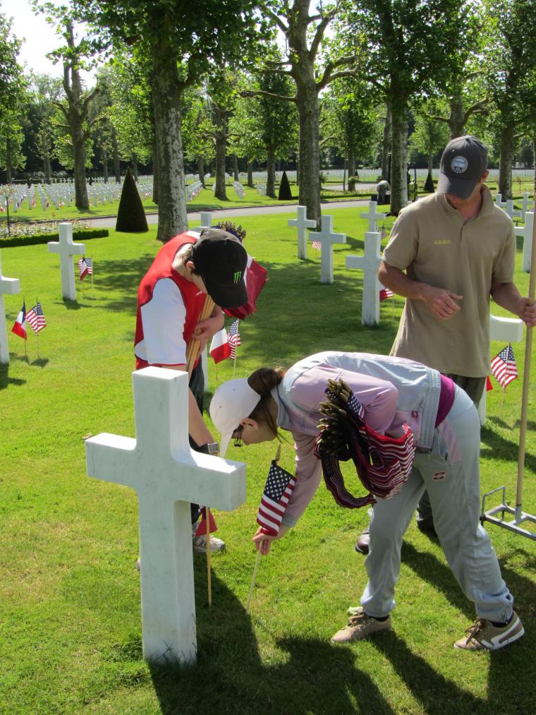 Students place American and French flags at every headstone. 