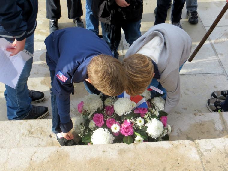 Boy scouts lay a floral wreath on the steps to the chapel. 