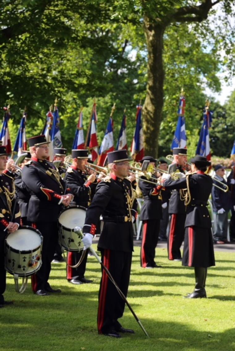 Men and women in uniform stand with their instruments. 