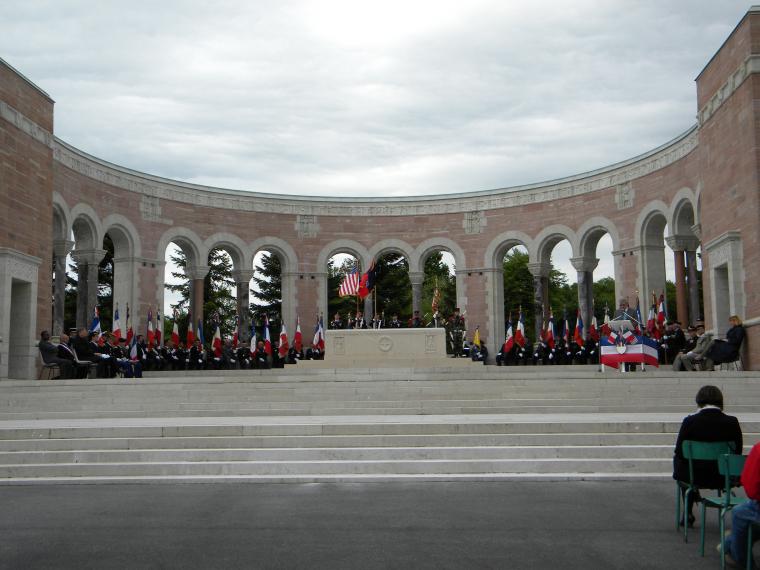 Participants sit in a semi-circle in the memorial area at the cemetery. 