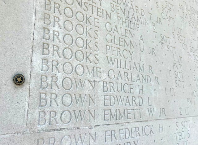 stone wall with bronze rosette next to the name of Bruce Brown