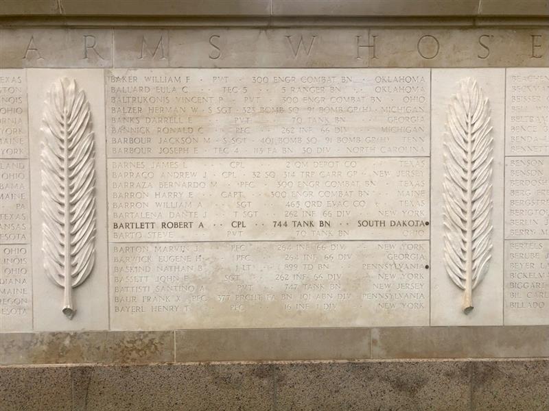 A rosette next to the name of Corporal Robert A. Bartlett on the wall of the missing