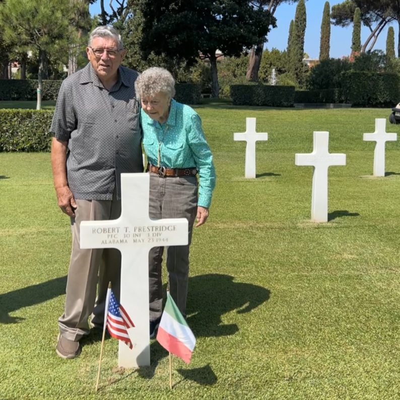 Travis Prestridge stands with his wife Arneta at his father’s grave, Pfc. Prestridge, who was killed in action during the breakout of the Anzio Beachhead on May 23, 1944, in World War II, as Sicily-Rome American Cemetery. 