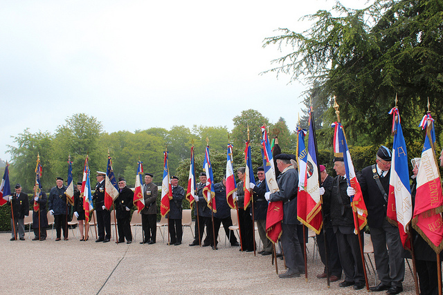 Participants stand with flags during ceremony. 