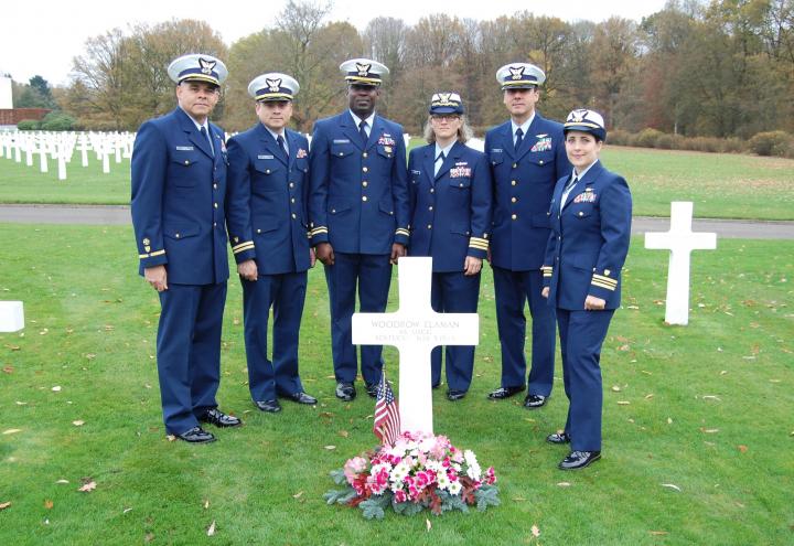 Six members of the Coast Guard stand at Elaman's headstone. 