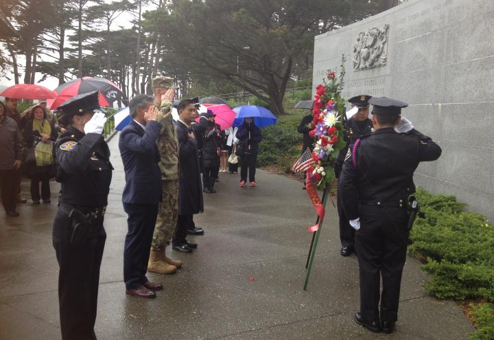 People salute after laying a wreath at the memorial. 