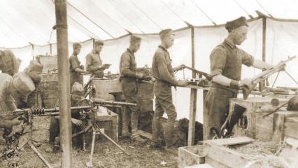 Soldiers of the 42nd Division's mobile ordnance shop repair machine guns for service.