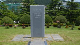 The words honor, freedom, and peace are inscribed on gray granite slab.