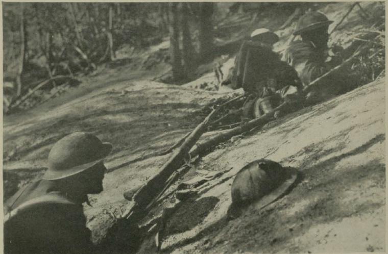 Historic image showing troops in fox holes. 