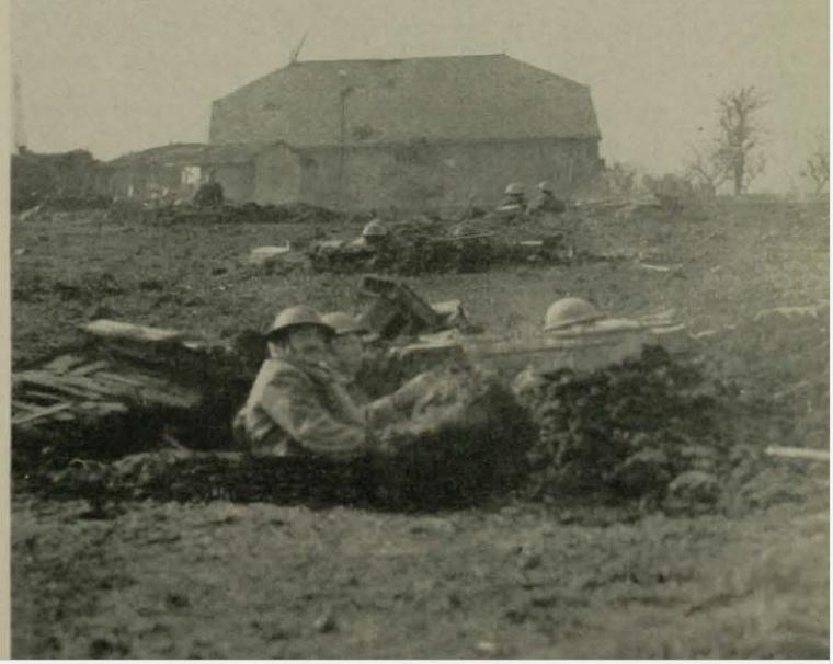 Historic image showing a machine gun unit firing from a trench. 