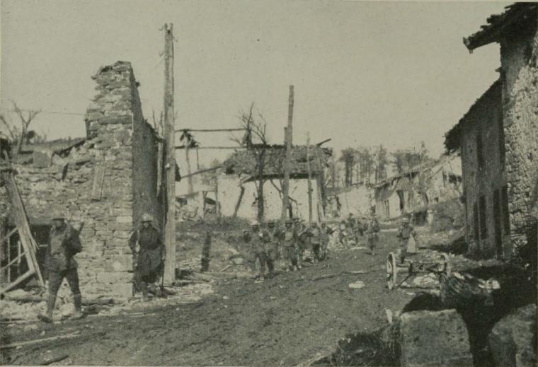 Historic image showing troops march through destroyed town of Cunel, France. 