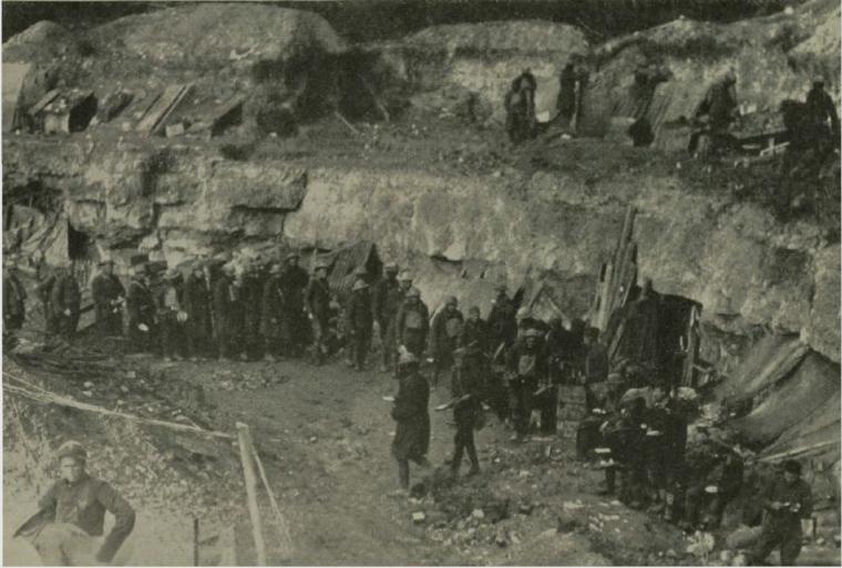 Historic image showing troops eating breakfast in a quarry. 