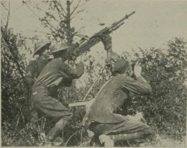 Historic image showing soldiers firing a machine gun. 
