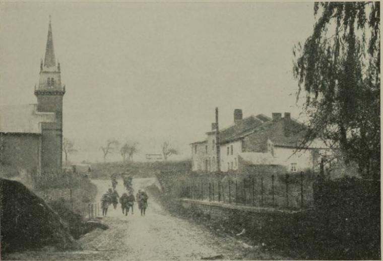 Historic image showing soldier under fire in the midst of a town.