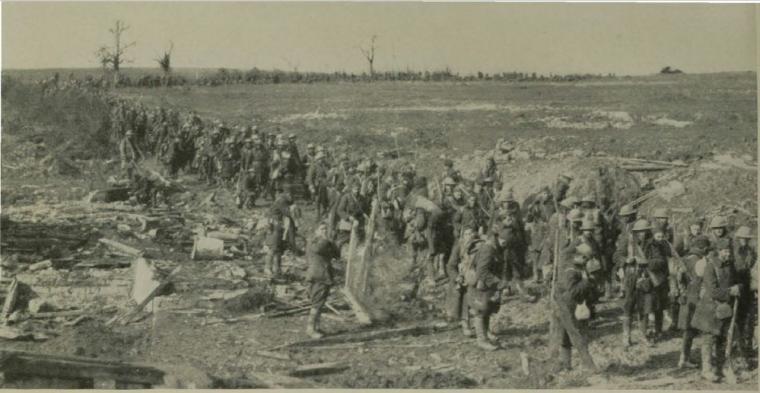 Historic image show soldiers marching through a devastated terrain. 