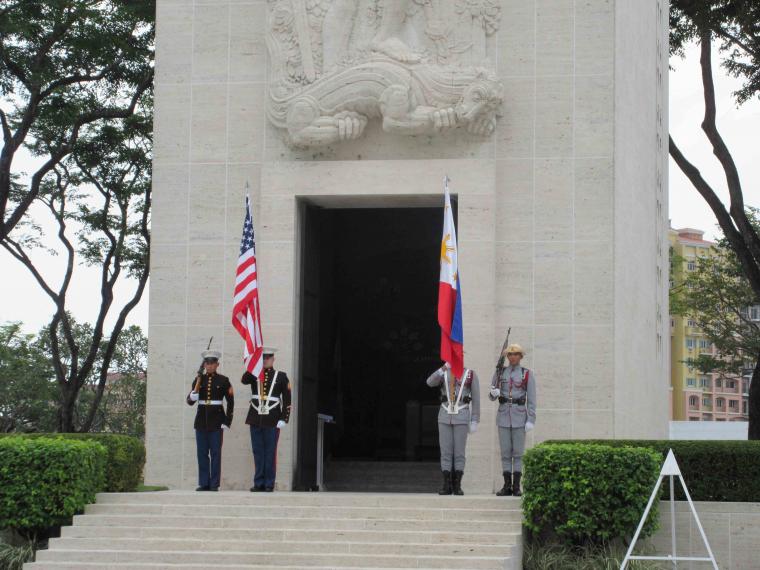 Members of the military stand with flags outside the chapel. 