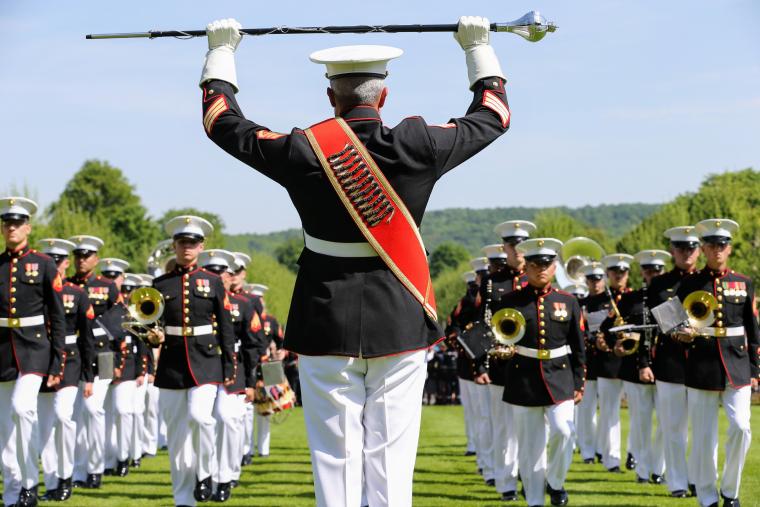 Members of the Marine band march in with their instruments.