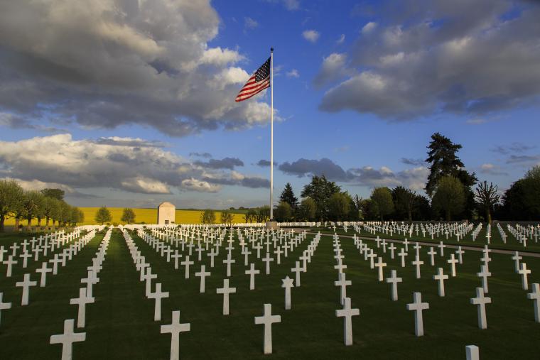 Marble headstones in rows are seen in front of the chapel at Somme American Cemetery. 