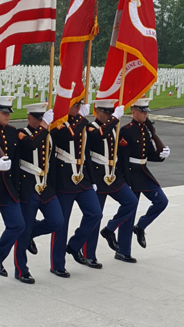 Marines in uniform march with the flags and rifles. 