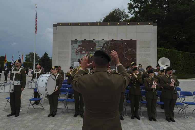 Members of the band perform in front of the battle map. 