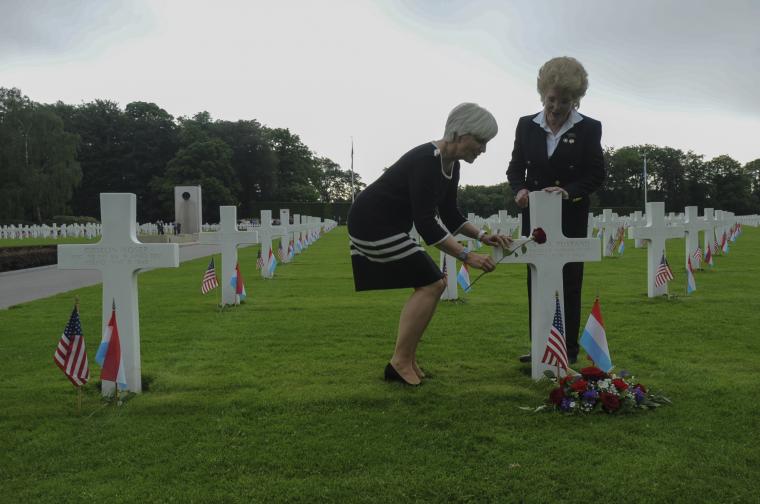 Two women stand near the headstone of 1st Lt. Handford Rustand. 