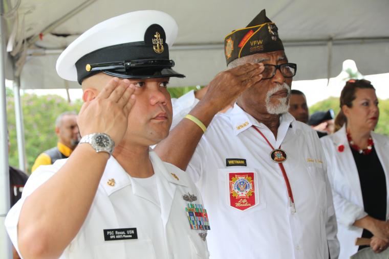 Two men stand and salute during the ceremony. 