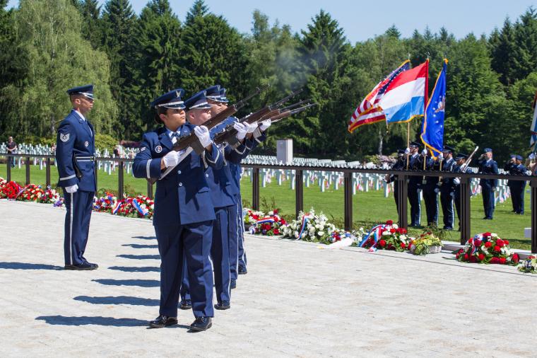 Men and women in uniform fire their weapons during the ceremony. 