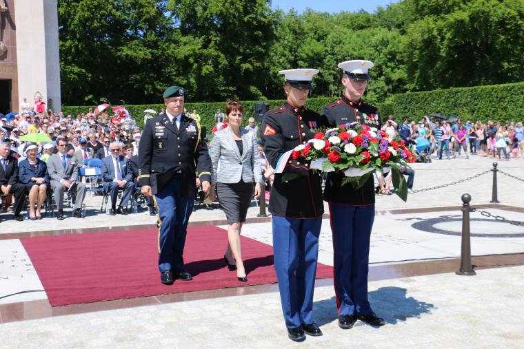 Two Marnes carry a floral wreath, followed by Evans and Shorter-Lawrence, who will lay the wreath.