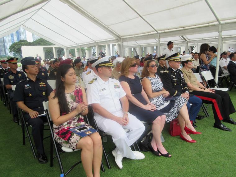 Attendees sit under a tent for the ceremony.