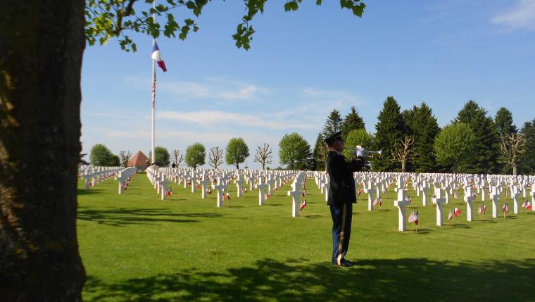 A bugler plays amongst the headstones.