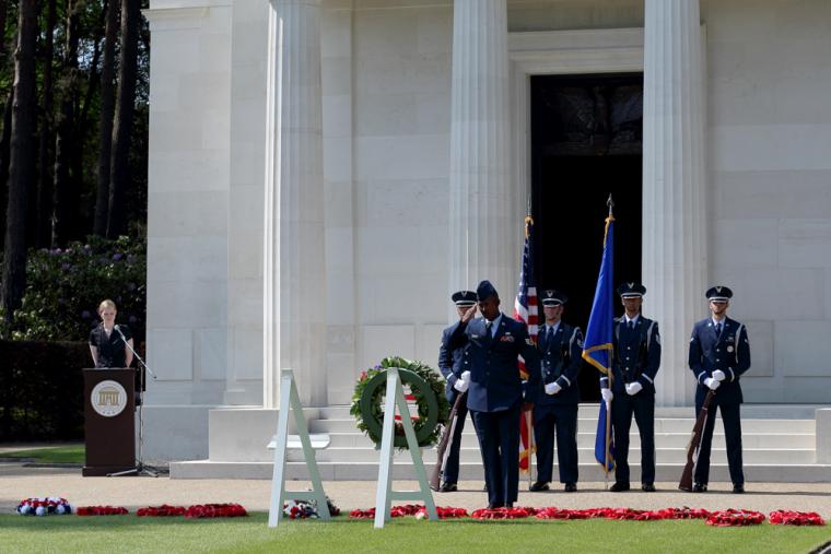 A man in uniform lays a wreath during the ceremony. 