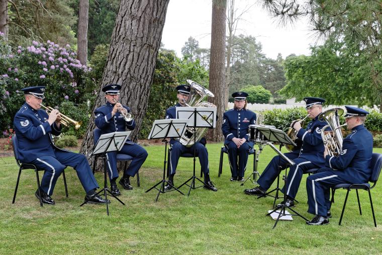 Men and women in uniform play their instruments.