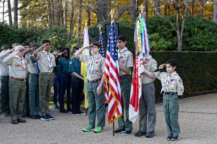 Boy Scouts stand with flags as they prepare to begin the ceremony.